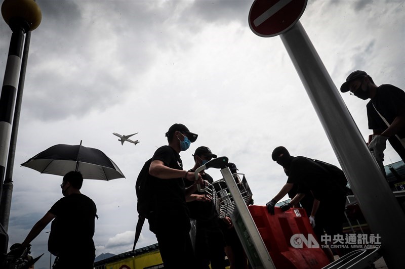 香港「反送中」網民發起1日下午堵塞機場行動,許多民眾響應聚集機場巴士總站,有示威者用行李車等物品試圖設置路障,封閉香港機場道路。中央社記者吳家昇攝 108年9月1日