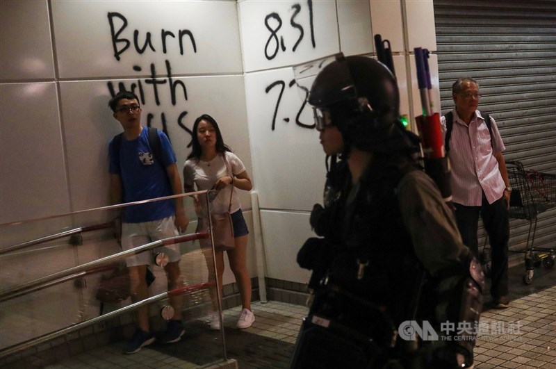 香港反送中運動延燒,示威者1日響應號召前往堵塞機場,部分示威者闖進地鐵東涌站進行破壞,警方晚間封閉東涌站,並在周邊搜捕示威者,有市民在一旁觀看。中央社記者吳家昇攝 108年9月1日