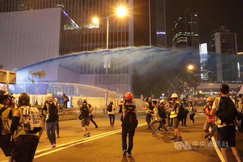 香港示威者28日晚間朝政府總部投擲汽油彈，港警於8時42分出動水炮車噴射藍色水柱及胡椒水。中央社記者張謙香港攝 108年9月28日