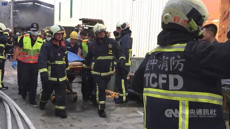 台中市大雅區一處鐵皮工廠3日凌晨發生大火,消防局獲報到場搶救,兩名消防人員進入火場救災時殉職,遺體運出時,在場消防人員列隊行禮,場面哀戚。中央社記者郝雪卿攝 108年10月3日
