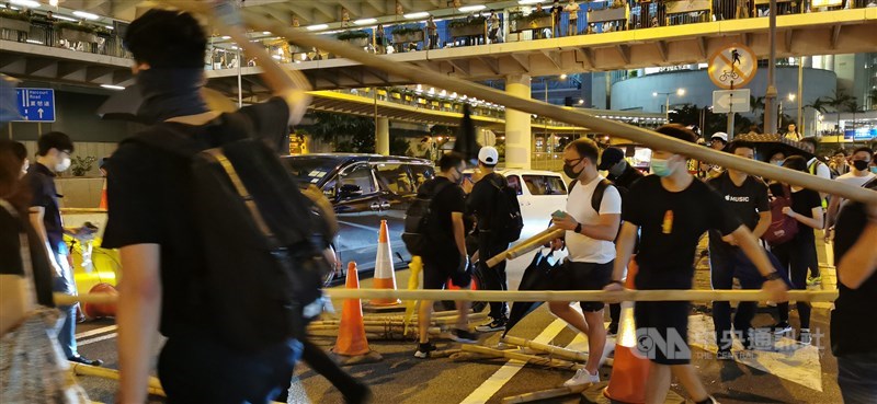 香港行政長官林鄭月娥4日宣布5日起正式實施「禁蒙面法」後,香港多地出現戴著口罩的示威者聚集抗議。圖為遊行人士堵住中環干諾道中的一條隧道。中央社記者張謙香港攝 108年10月4日