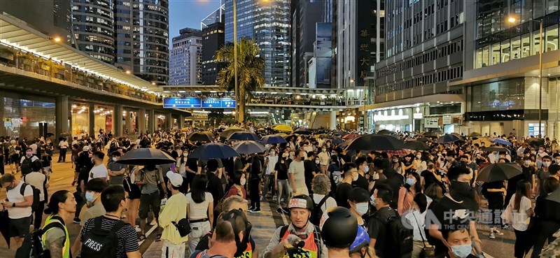 香港行政長官林鄭月娥今天宣布實施「禁蒙面法」後,香港多地出現戴著口罩的示威者聚集抗議。圖為示威人士在中環干諾道中聚集抗議,高呼「香港人,反抗」及「時代革命」等口號。中央社記者張謙香港攝 108年10月4日