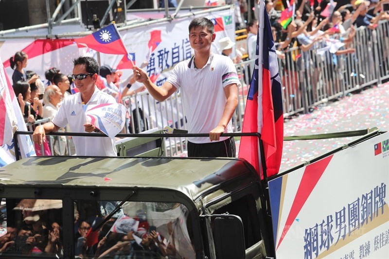 2019台灣英雄大遊行10日自愛國西路小南門集結出發,途經館前路與漢口街交叉口,世大運網球男團銅牌選手吳東霖(右)向民眾揮手致意。中央社記者吳家昇攝 108年10月10日