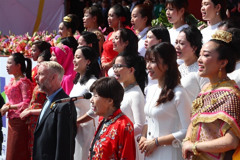 108年國慶大會10日上午在總統府前廣場舉行,由歸化取得中華民國國籍的神父雷敦龢(前排右2)和鋼琴家藤田梓(前排右),與30名東南亞新住民共同唱國歌。中央社記者王騰毅攝 108年10月10日