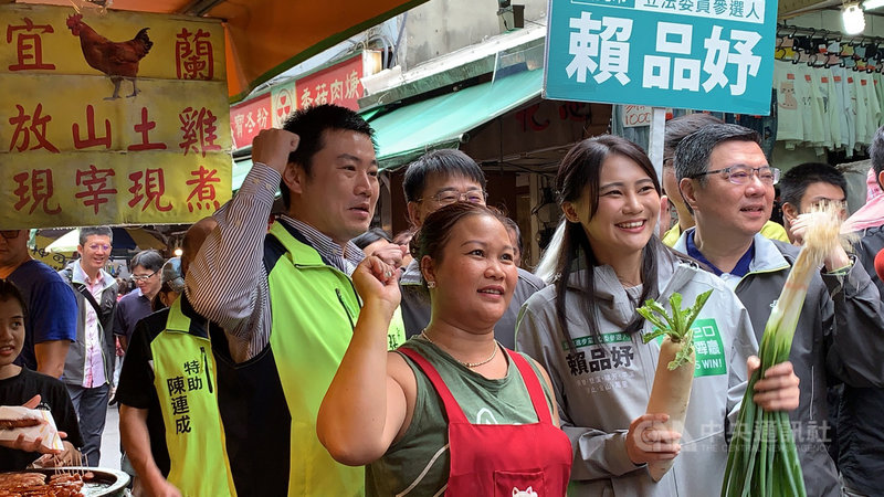 民進黨主席卓榮泰(前右)12日上午陪同立委參選人賴品妤(前右2)到汐止掃街拜票,有攤商熱情送上象徵好彩頭的白蘿蔔與蒜苗,高喊「凍蒜」。中央社記者葉臻攝 108年10月12日