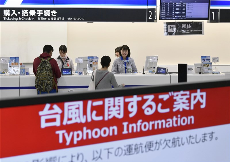 颱風哈吉貝襲日本,許多航班取消,大阪機場的航空公司人員向旅客說明。(共同社提供)
