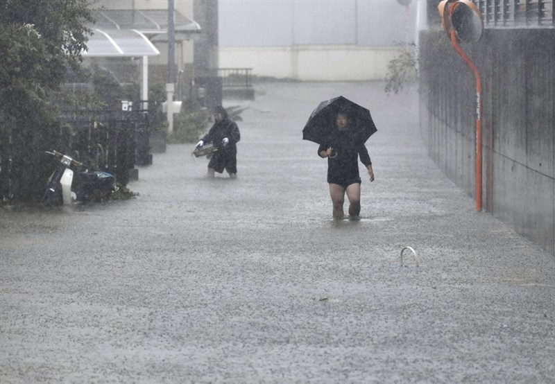 颱風哈吉貝來帶大雨,日本靜岡縣静岡市街道水淹至民眾小腿肚,一旁機車也泡在水裡。(共同社提供)
