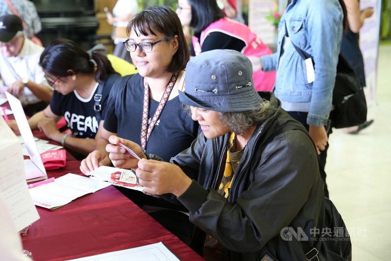 花蓮慈濟醫院與器官捐贈移植登錄中心14日在醫院大廳,舉辦支持器官捐贈宣導活動,王媽媽(右)與女兒(右2)一起簽署器官捐贈同意書,領到器捐卡的王媽媽仔細端看卡片。(花蓮慈濟醫學中心提供)中央社記者李先鳳傳真 108年10月14日