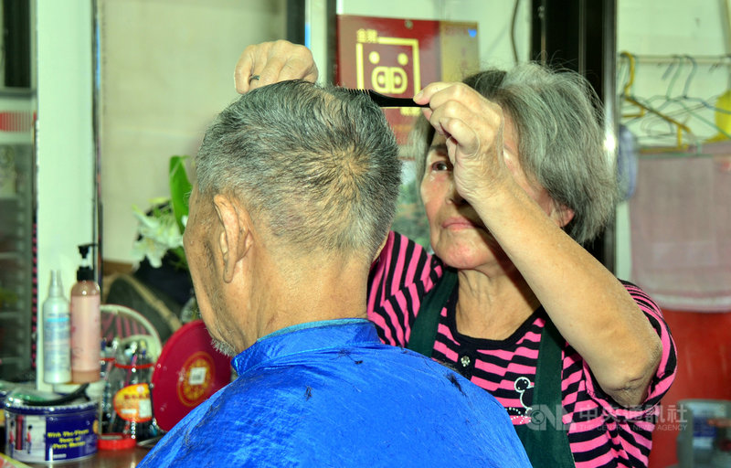 90歲的吳姓老翁(左)每個月堅持要讓79歲的理髮師傅韓梅子(右)剪頭髮,韓梅子說,從民國55年到現在,吳先生每個月都會到這裡理髮,已有53年,「這個頭我剪超過600次了」。中央社記者盧太城台東攝 108年10月15日