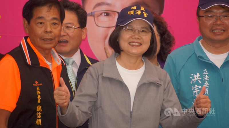 總統蔡英文（右2）16日到彰化埔鹽鄉順澤宮上香，廟方贈送因挪威三鐵選手艾登戴著奪冠爆紅的「冠軍帽」，蔡總統戴上帽子、比出手勢，跟民眾一起合影留念。中央社記者吳哲豪彰化攝　108年10月16日