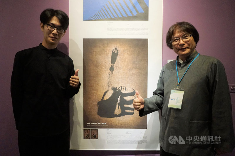 2019金門國際和平海報獎巡迴展金門場19日開幕,銅獎得主、亞洲大學視覺傳達設計系學生王鼎鈞(左)的作品「非攻」,以握緊的拳頭和大拇指上方發射的砲彈,述說對於維持和平的期待。中央社記者黃慧敏攝 108年10月19日