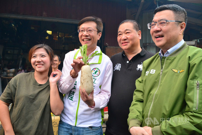 民進黨主席卓榮泰(右)21日傍晚陪同力拚連任的黨籍立委張宏陸(左2)在板橋區的市場掃街拜票,張宏陸拿著象徵「好彩頭」的白蘿蔔開心留影。中央社記者黃旭昇新北市攝 108年10月21日