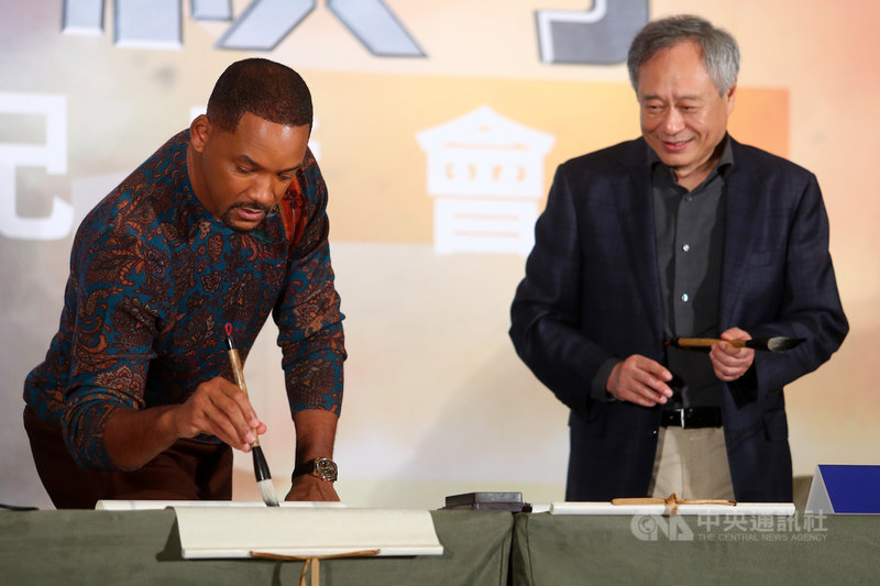 導演李安(右)執導新片「雙子殺手」,21日與片中主演威爾史密斯(Will Smith)(左)在台北宣傳,威爾史密斯現場拿起毛筆,體驗揮毫。中央社記者王騰毅攝 108年10月21日