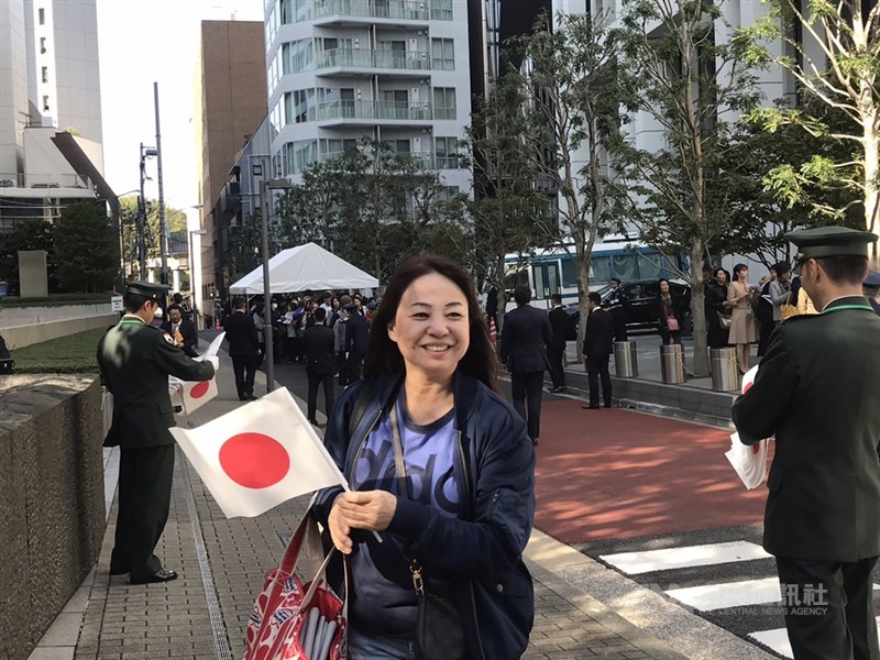 日皇德仁即位遊行「祝賀御列之儀」10日下午登場,不少民眾提前在遊行路線附近排隊,圖為一位女士拿著日本國旗興奮等待。中央社記者楊明珠東京攝 108年11月10日