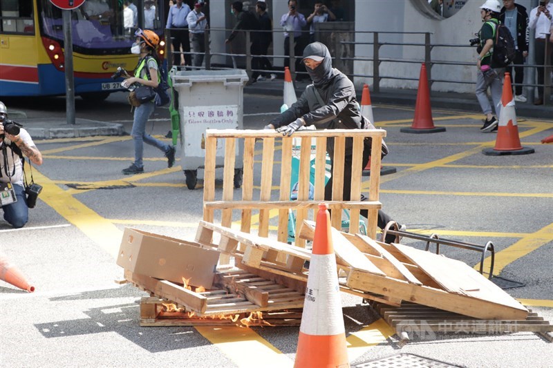 11日下午1時30分左右,警方再度在畢打街釋放催淚彈。防暴警察離去後,示威者又再堵路並焚燒雜物。中央社記者張謙香港攝 108年11月11日