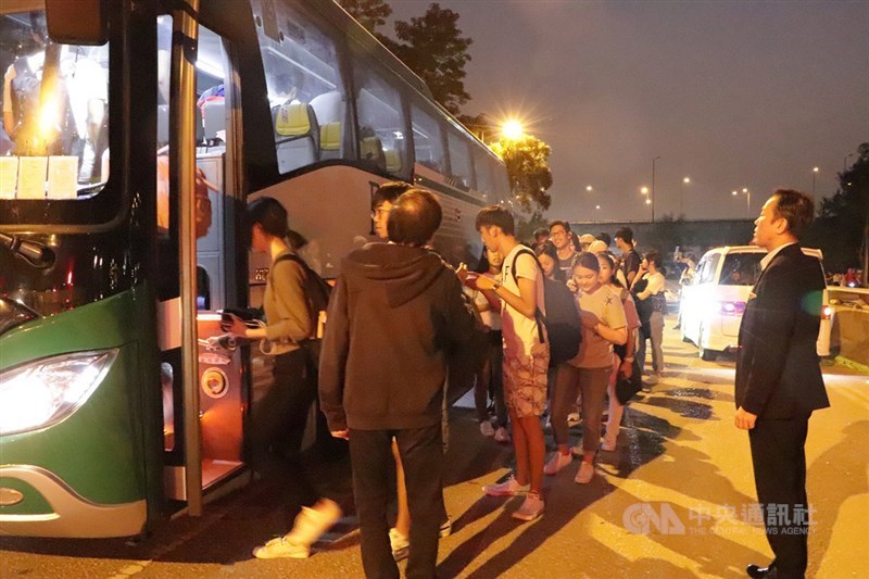 香港中文大學連日發生嚴重警民衝突,香港台北經濟文化辦事處13日晚應要求協助該校台生返台。圖為台生集體步出校園外搭乘專車前往機場。中央社記者張謙香港攝 108年11月13日