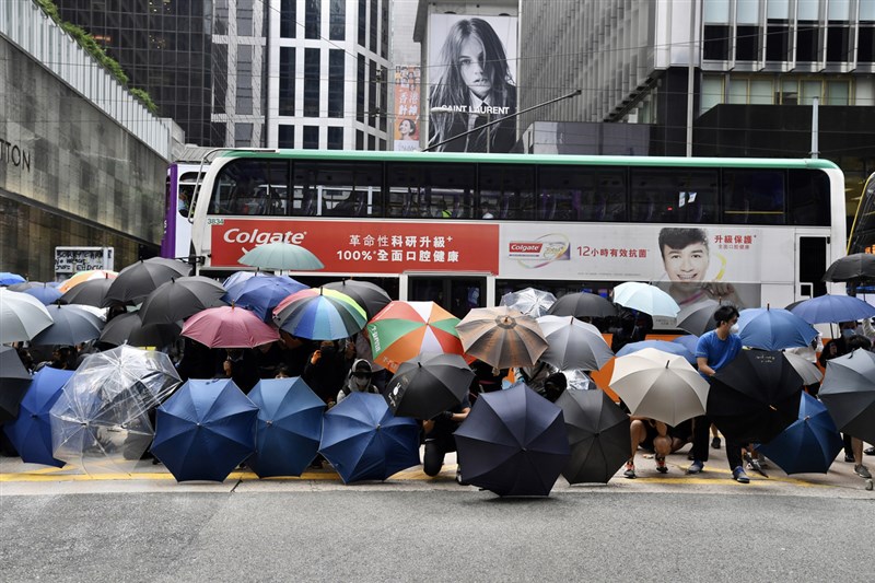 香港「反送中」支持者12日連續第2天發起「三罷」,多名示威者中午在中環鬧區以傘陣堵路。(中通社提供)