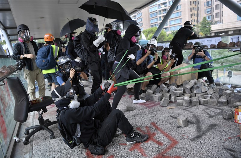 反送中示威者12日上午集結於香港歌和老街近城市大學學生宿舍一段,警方到場驅散時,在橋上的示威者以大型彈弓向警員發射石塊並丟擲汽油彈。(中通社提供)中央社 108年11月12日