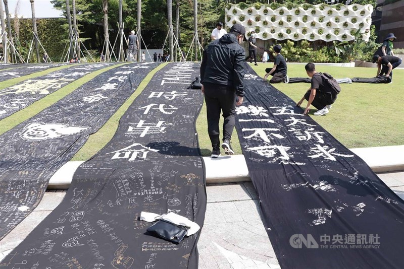 吳叡人指出,反送中抗爭運動的導火線「逃犯條例修正案」就是法律上與中國進行統合,香港人對於法治將毀的危機感整個爆發出來。圖為反送中示威者寫「時代革命」「五大訴求,缺一不可」口號布條。(中央社檔案照片)