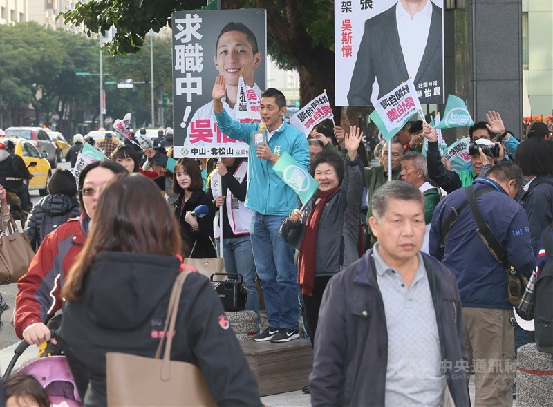 總統府祕書長陳菊（木箱右）10日一早陪同民進黨台北市第3選區（中山、北松山）立委參選人吳怡農（木箱上），站在台北市民生東路2段、松江路口，向路過民眾揮手拜票，爭取支持。中央社記者謝佳璋攝 108年12月10日