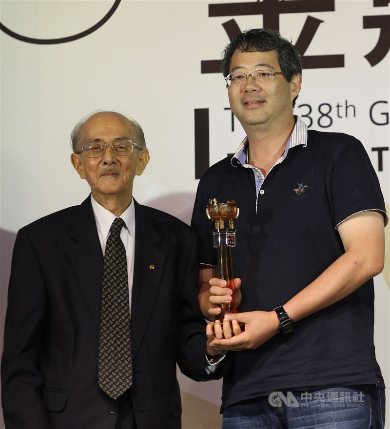 第38屆金鼎獎頒獎典禮2014年8月13日在松山文創園區舉行,資深作家林良(左)頒發雜誌類攝影獎給得獎人齊柏林(右)。(中央社檔案照片)