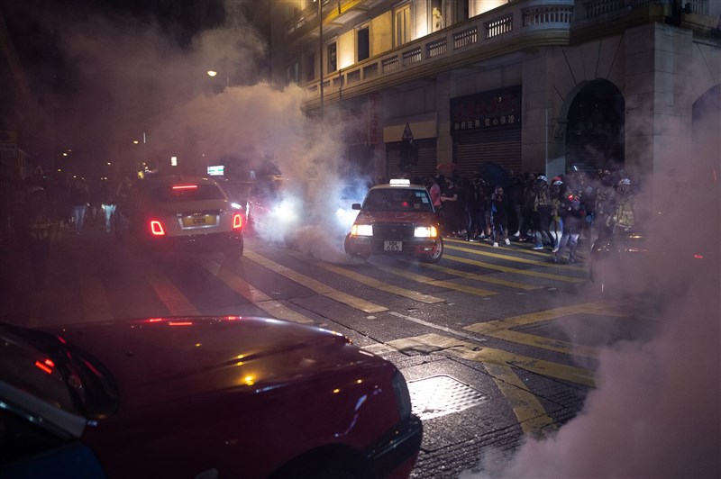 在耶誕平安夜,香港多處仍有「反送中」示威者聚集,防暴警察予以驅散。(法新社提供)