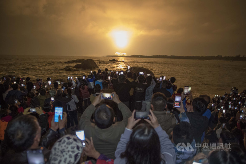 中國長征五號遙三運載火箭27日晚間在海南文昌航天發射場發射,吸引許多民眾圍觀拍攝升空鏡頭。(中新社提供)中央社 108年12月28日