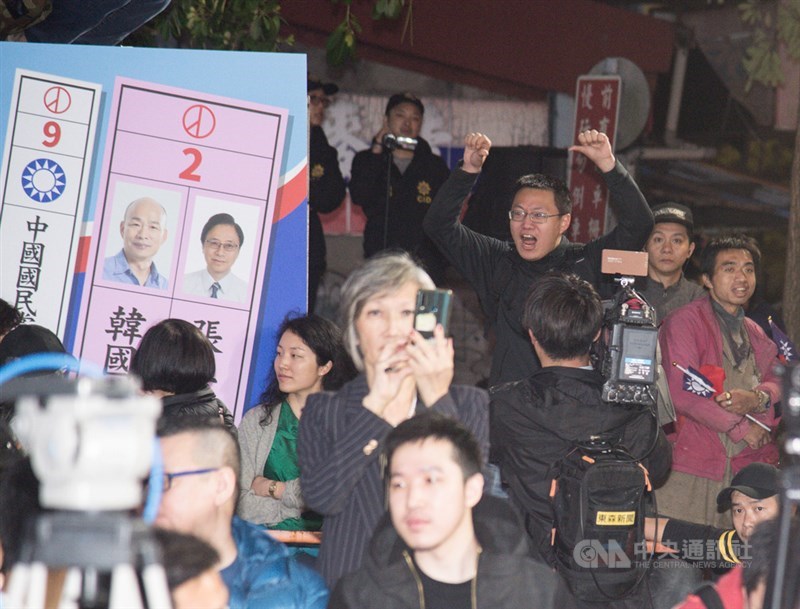 2020總統大選及立委選舉11日晚間結果陸續揭曉,一名男子(後右黑衣)在國民黨中央黨部外比出倒讚並激動喊話,要求黨主席吳敦義下台以示負責。中央社記者林俊耀攝 109年1月11日