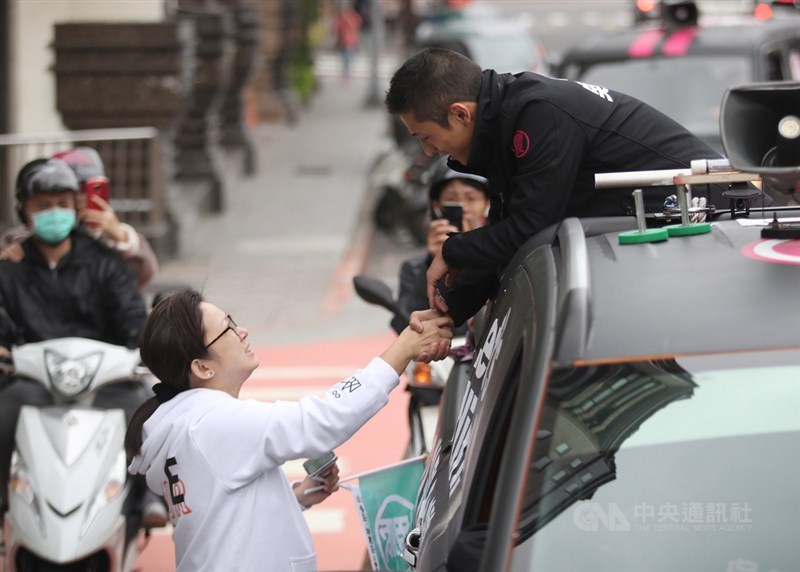 2020總統立委選舉結果出爐,民進黨立委候選人吳怡農(右)落敗,12日展開車隊謝票行程,與民眾握手致意並表達感謝。中央社記者張新偉攝 109年1月12日