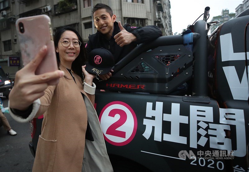 2020總統立委選舉結果出爐,民進黨台北市第3選區立委候選人吳怡農(右)落敗,12日展開車隊謝票行程,許多民眾跑到車旁與吳怡農合影留念。中央社記者張新偉攝 109年1月12日