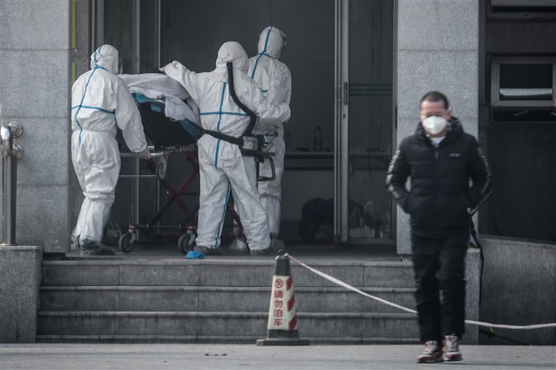 2019新型冠狀病毒肺炎疫情在中國持續蔓延,已經擴散至北京、深圳、上海等地。圖為醫護人員將患者送入前往專門收治武漢肺炎的金銀潭醫院。(法新社提供)