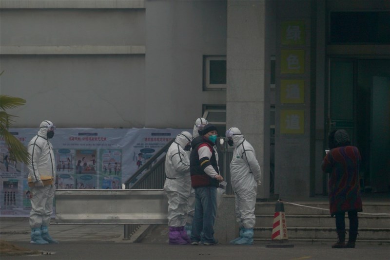 中國一篇有關武漢肺炎的研究顯示新型冠狀病毒自2019年12月中就出現人傳人,與官方通報兜不攏。圖為武漢醫療救治中心外,醫護人員穿著防護隔離衣。(美聯社)