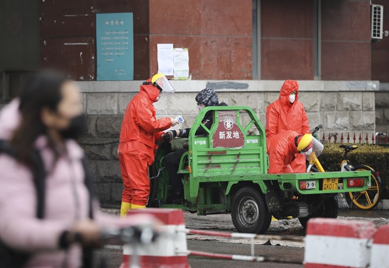 穿著防護衣的防疫人員2日北京新發地市場為進出人員測量體溫。(中新社提供)