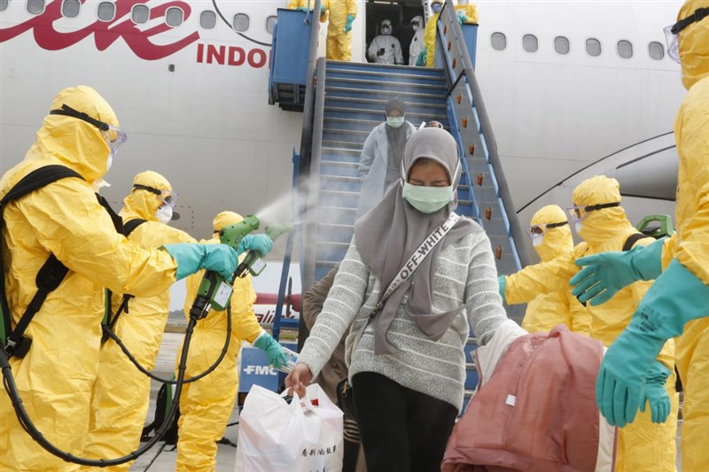 印尼政府的撤僑專機2日返抵巴淡島,自湖北省返國的國人下機後先噴灑消毒液,再搭軍機接駁至納土納縣的軍醫院隔離觀察。(印尼外交部提供)中央社記者石秀娟雅加達傳真 109年2月2日