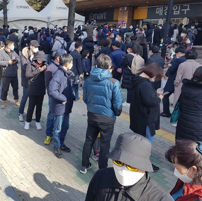 武漢肺炎疫情升溫,大邱市街道出現搶購口罩人潮。圖為大邱民眾24日排隊購買口罩。(韓聯社提供)
