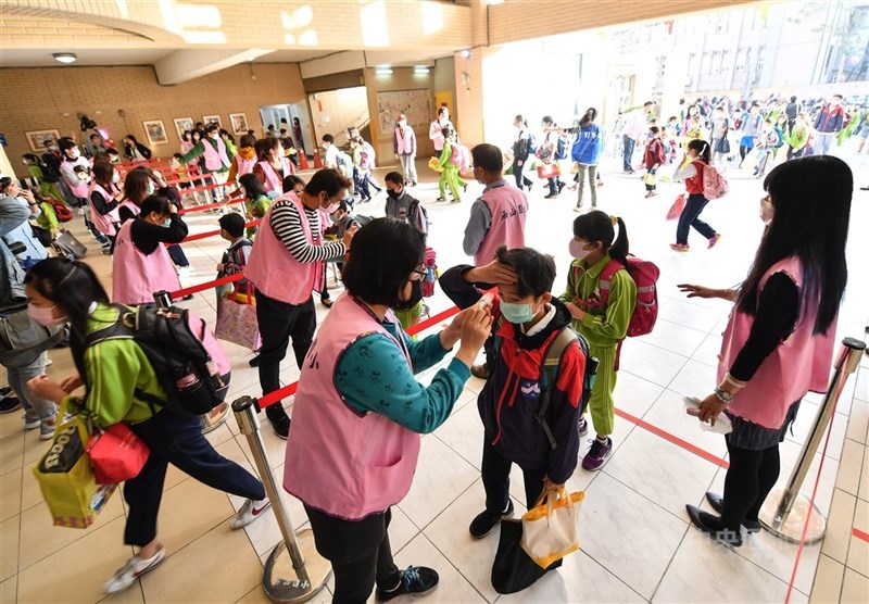 日媒報導,台灣政府早在2月2日就宣布高中以下學生寒假延長2週,有學校就利用這段時間準備180個體溫計,並且與家長溝通好學童上學時的規定。圖為新北市海山國小2月25日開學首日,學童逐一測量額溫後才能進入校園。中央社記者林俊耀攝 109年2月25日