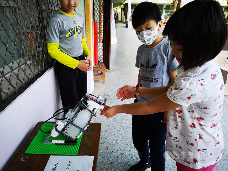 因應武漢肺炎疫情,高雄市林園國小師生以樂高積木自製的酒精噴霧機器人消毒雙手,吸引外媒路透社9日到校探訪,大讚校方的創意。(高市教育局提供)中央社記者程啟峰高雄傳真 109年3月10日