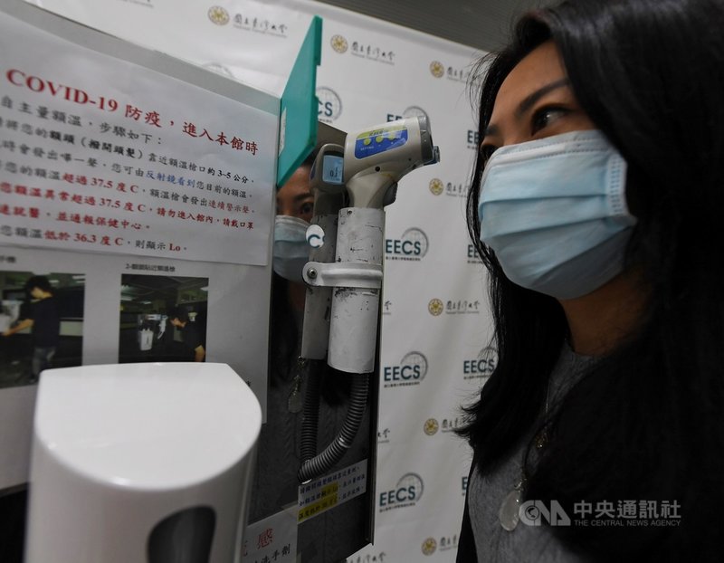 國立台灣大學電資學院10日舉行記者會,說明由電機系所研發的智慧防疫裝置「防疫1號」,可降低管控人力需求,大量推廣。圖為人員示範自行將額頭靠近量額溫。中央社記者施宗暉攝 109年3月10日