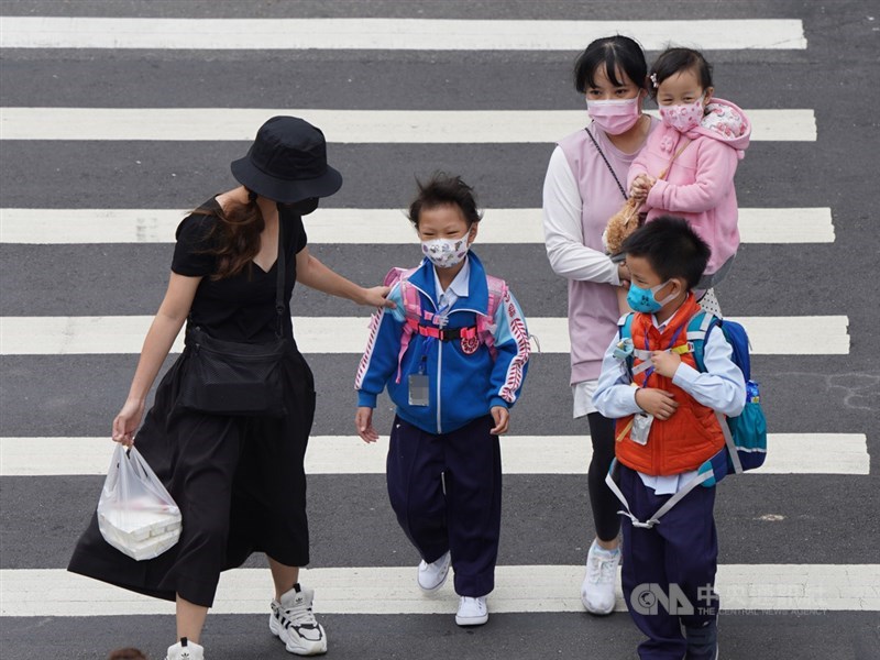 副總統陳建仁23日在臉書分析目前各國武漢肺炎疫情仍處上升階段,待緩和至少還需兩個月時間。圖為北市家長帶孩童外出,為他們戴好口罩。中央社記者徐肇昌攝 109年3月23日