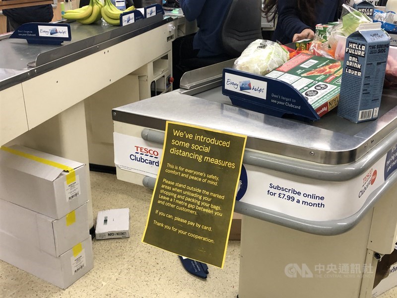 倫敦超市收銀台前張貼告示,要求顧客保持距離,且最好以信用卡付款,避免接觸。中央社記者戴雅真倫敦攝 109年3月20日