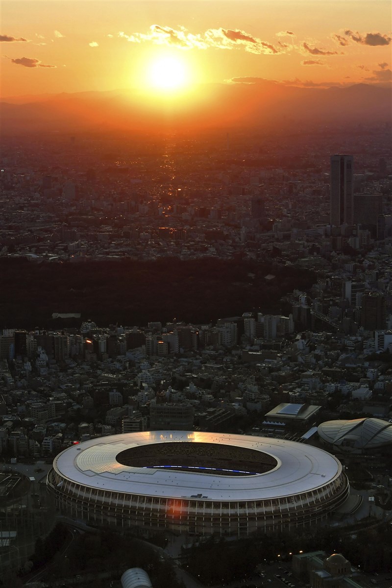東奧延期一年舉行,日本觀光產業可能面臨預約取消、觀光需求減少等衝擊。圖為夕陽下的東奧主場館。(檔案照片/共同社提供)