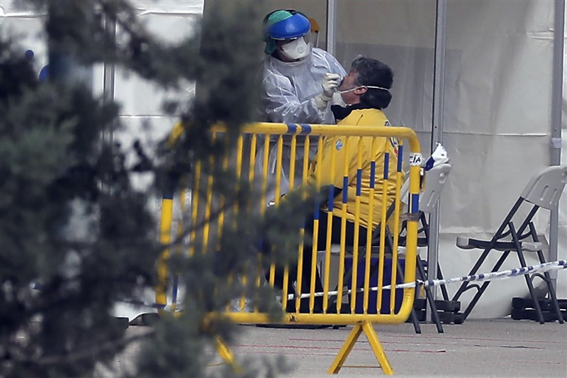 西班牙衛生部30日數據指出,新增6398起武漢肺炎確診病例,累計確診數8萬5195例,超過中國官方通報數字。圖為西班牙馬德里醫護人員對民眾採檢。(美聯社)