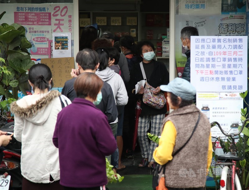 疫情指揮中心研擬對沒有維持適當社交距離者開罰。衛福部30日指出將先「訂指引」再「輔導教育推動」讓民眾「養成習慣」,最後才對不配合對象開罰。圖為藥局前民眾排隊購買口罩。(中央社檔案照片)