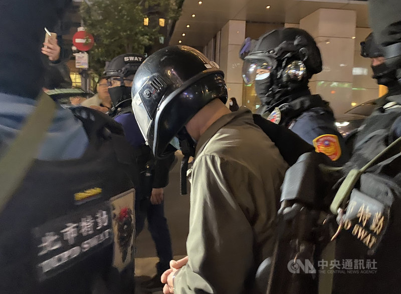 54歲陳姓男子(中)因缺錢花用,30日上午持M4改造長槍行搶台北市板信商業銀行大直分行,他8年前也曾持刀搶劫彩券行;警方31日下午在桃園逮人,晚間7時帶回警局偵辦。中央社記者黃麗芸攝 109年3月31日