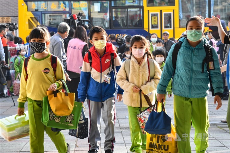 目前有超過160個國家已經勒令學校關閉,全球近9成學生不用上課,然而台灣、新加坡、澳洲的學校都仍正常上課,截然不同的表現吸引外媒撰文討論。圖為學童戴口罩上學。(中央社檔案照片)