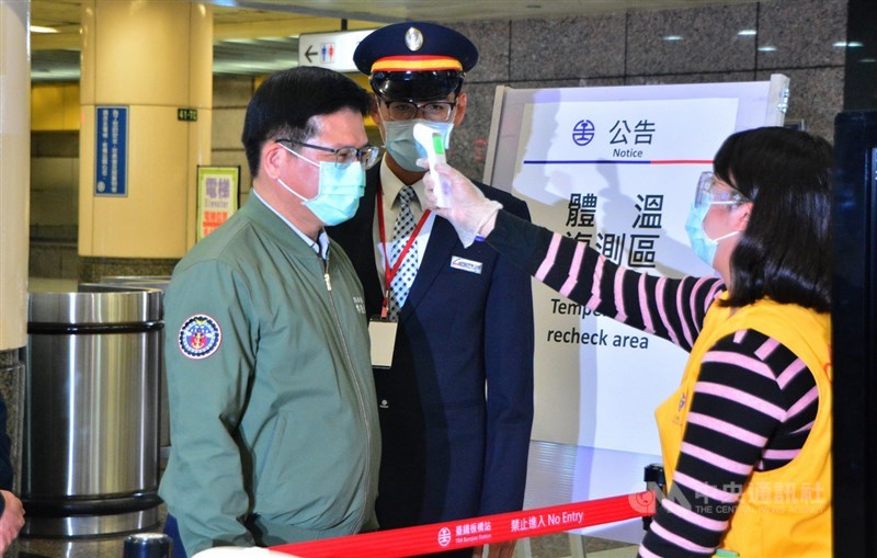 清明連假將至,交通部長林佳龍(前左)31日晚上視察台鐵、高鐵板橋車站的防疫措施,體驗公共運輸防疫同仁為旅客測量體溫,並呼籲民眾配合防疫。中央社記者黃旭昇新北攝 109年3月31日