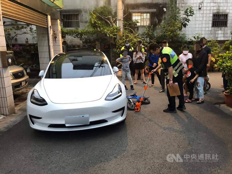 台中市大里區一名5歲男童3日傍晚騎腳踏車撞到停在民宅門口的特斯拉電動車,楊姓車主報案後,警方到場依規定測量距離。(楊姓車主提供)中央社記者郝雪卿傳真 109年4月4日