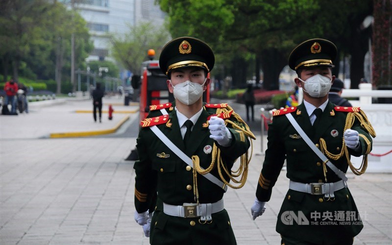 中國的2019冠狀病毒疾病疫情趨緩,但仍面臨境外輸入和無症狀感染者挑戰。圖為人民廣場前戴上口罩行進的衛兵。中央社記者沈朋達上海攝 109年4月4日