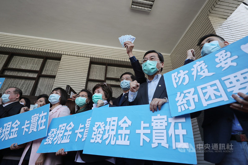 國民黨立法院黨團10日在立法院議場前舉行記者會,高舉「發現金 卡實在」看板,指出目前民眾對政府的口罩政策及酷碰券仍有爭議,呼籲增加口罩片數,並直接發放現金,讓人民有感。中央社記者裴禛攝 109年4月10日