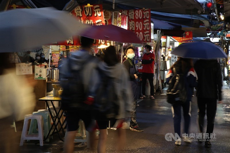 指揮中心10日宣布,即日起針對觀光景點、夜市等人潮密集公共場所實施人流管制,攤商及消費者應全程配戴口罩。圖為民眾逛夜市,店家戴上口罩迎接客人。中央社記者張新偉攝 109年4月6日